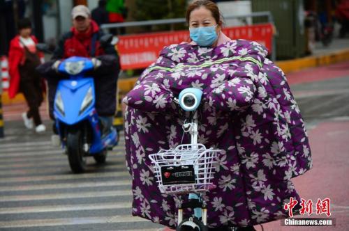 10月9日，内蒙古多地大幅降温，在呼和浩特街头，骑电动车的行人穿上“棉衣”出行。 <a target='_blank' href='http://www.chinanews.com/'>中新社</a>记者 刘文华 摄