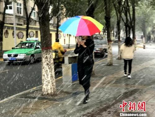 图为9日西宁市区飘起鹅毛般大雪，市民撑伞行走。　孙睿 摄