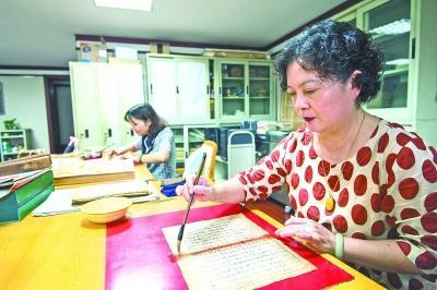 武汉市图书馆的古籍修复非遗传承人贺琳在补缺口
