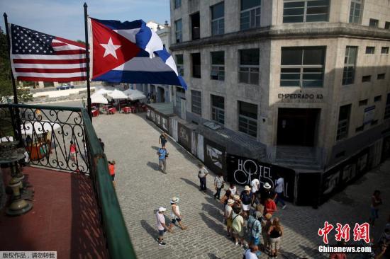 美国和古巴的旗帜飘扬在一家餐馆的阳台上。