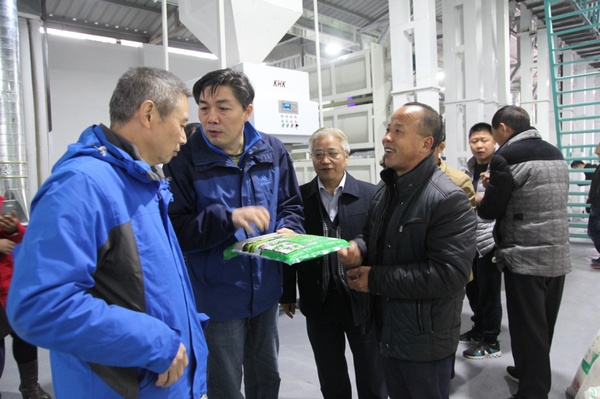 长阳土家族自治县农业局局长程刚（左二）现场了解大米包装情况