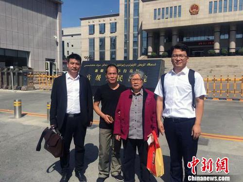王兴律师与李碧贞及周远在新疆高级人民法院门前合影。　王兴 摄