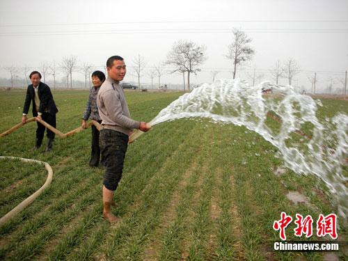 资料图：农民春节期间在田间浇麦抗旱。
