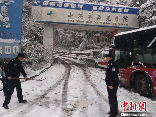 湖北十堰普降大雪，民警除雪保道路畅通 刘英 摄