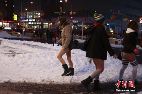 当地时间1月7日，纽约女子在曼哈顿的地铁里参加“不穿裤子搭地铁”活动时穿行雪地。 中新社记者 廖攀 摄