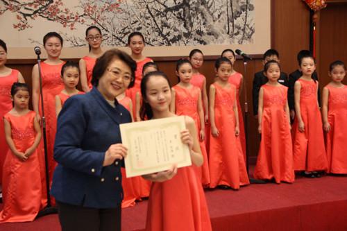 中国侨网东方文化协会理事长高山英子（左）向合唱团成员颁发奖状。