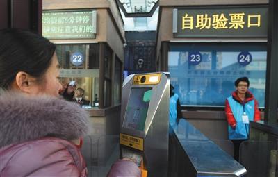 昨日，北京站乘客使用自助验票机。