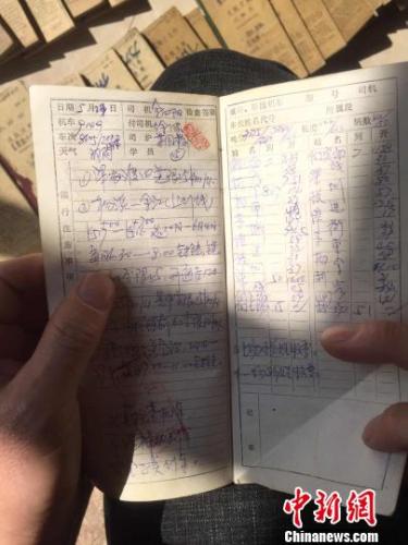 时代在变，但这位“老司机”认真记录手账的习惯从未改变，他仔细记下了84本手账。　袁艺 摄