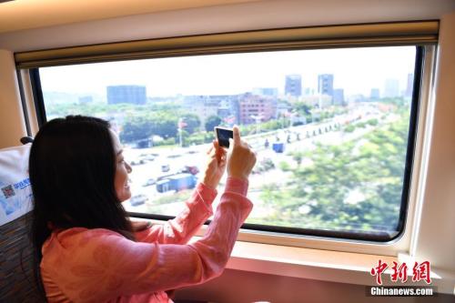 图为“复兴号”高铁旅客拿手机拍摄窗外景色。 <a target='_blank' href='http://www.chinanews.com/'>中新社</a>记者 陈文 摄
