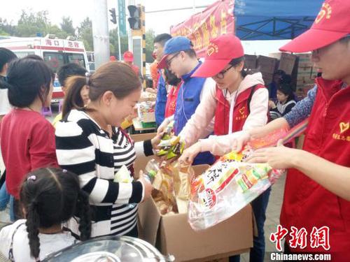 2月21日，海口新海港附近，志愿者为旅客发放食物。　尹海明 摄