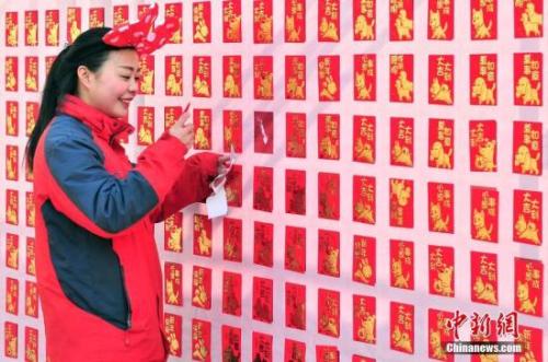 资料图：2018年2月16日，大年初一，游客来到天津方特欢乐世界红包墙前抢包红。<a target='_blank' href='http://www.chinanews.com/'>中新社</a>记者 佟郁 摄