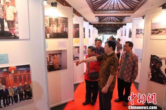 中国侨网由中国驻印尼登巴萨总领馆举办的“新时代中国”大型图片展，21日在印尼巴厘艺术中心开幕。图为中国驻印尼登巴萨代总领事陈巍（前）与来宾一同参观图片展。
