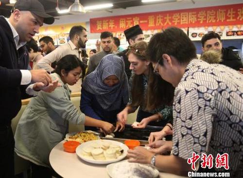 中国侨网图为重庆大学留学生包饺子和汤圆共庆元宵节。　钟欣　摄