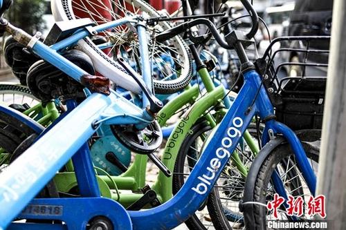 资料图：广州，一辆小蓝单车与其它品牌的共享单车被堆放在路边。<a target='_blank' href='http://www.chinanews.com/'>中新社</a>记者 陈骥旻 摄