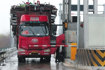 4月13日，京津高速台湖收费站，一名大货车司机从车上下来取高速卡。本版摄影/新京报记者 朱骏