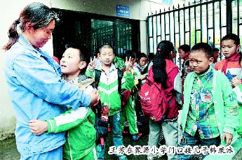 王芳在聚源小学门口接儿子韩康泳。本报记者  田福良  摄