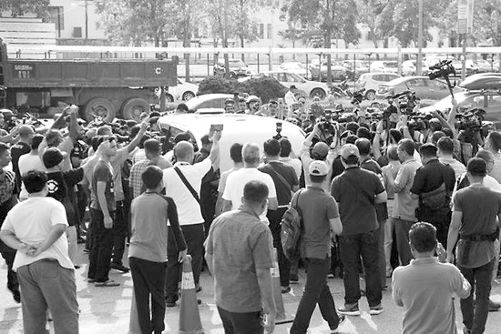马来西亚民众12日在吉隆坡机场外围堵一辆疑似纳吉布夫妇乘坐的汽车。