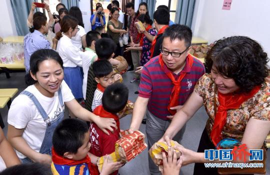 志愿者向孩子们赠送儿童节小礼物。　王旺旺 摄