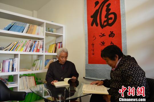 图为两位老年人正在日间照料中心阅读书籍。资料图 丁洪 摄