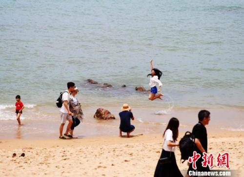资料图：端午假期，游客在三亚海边嬉水。　王晓斌 摄