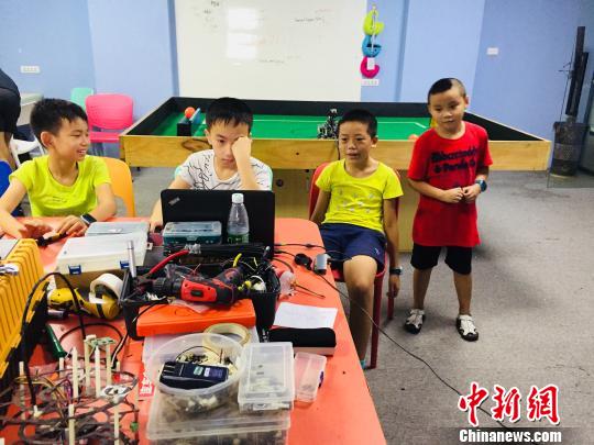 7月21日，在广西柳州一家培训机构，学生动手制作机器人。　周潇男 摄