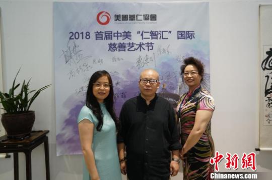 中国侨网美国华仁协会执行主席魏峰青（左）与艺术家王本杰（中）及工作人员合影。　主办方供图　摄