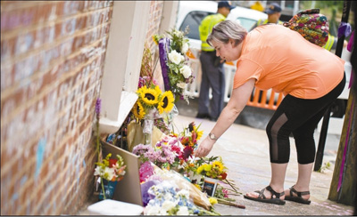今年8月12日是美国弗吉尼亚州夏洛茨维尔“白人至上”骚乱一周年。图为11日，在美国夏洛茨维尔市，一名妇女摆放花束悼念去年骚乱中的遇难者。新华社发