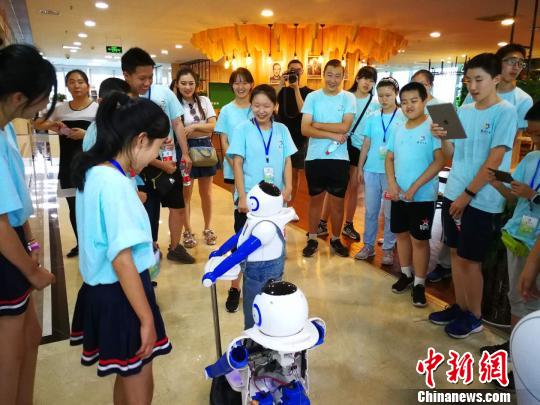 营员参观高新技术企业，与赵宇机器人互动。　杨杰英 摄
