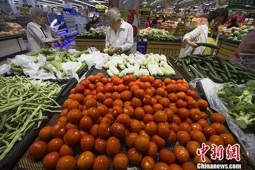 资料图：民众在菜场购买蔬菜。 中新社记者 张云 摄
