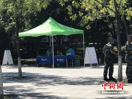 中国电信在某高校内摆摊出售手机卡，旁边就是正在军训的学生。<a target='_blank' href='http://www.chinanews.com/' >中新网</a> 吴涛 摄