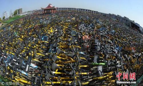 资料图：堆积成山的共享单车。图片来源：视觉中国