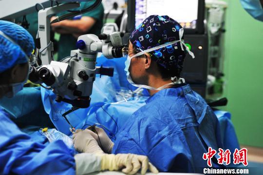 图为9月28日，北京同仁医院副院长、眼科主任魏文斌(右)主刀为患者进行了微创玻璃体视网膜手术。　张伟 摄
