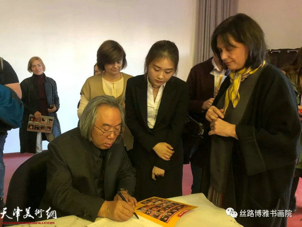 霍春阳在“中国画精神的内涵”讲座现场为喜爱中国书画的俄罗斯大学生签名留念。