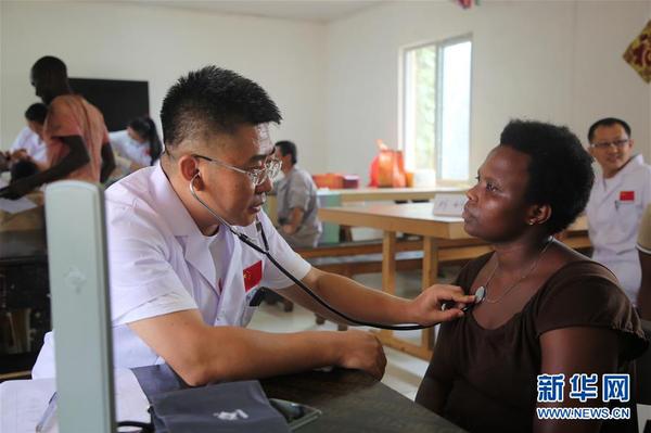 　12月3日，在卢旺达首都基加利，一名中国医疗队医生为中国援卢旺达政府综合办公楼项目的员工检查身体。2