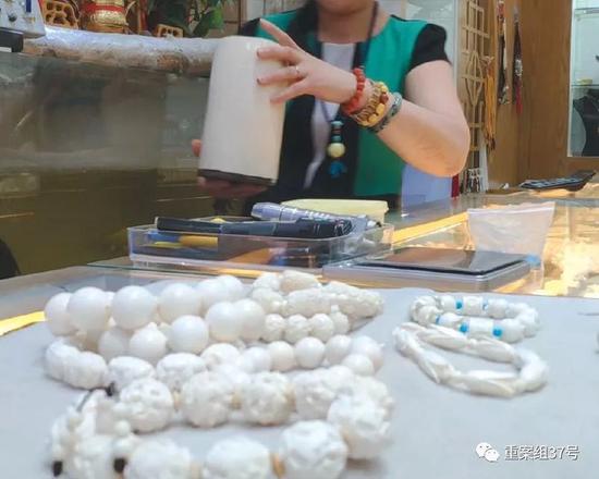 2018年8月11日，北京十里河雅园国际珠宝厅内，一猛犸象牙销售商向记者展示店内隐藏的现代象牙制品，其手中拿的是现代象牙所制的笔筒。  新京报记者王嘉宁 摄