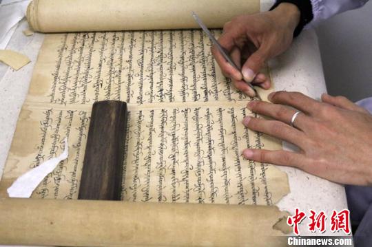 图为文物保护专家正在对唐代藏文写经进行修复。　赵红云 摄