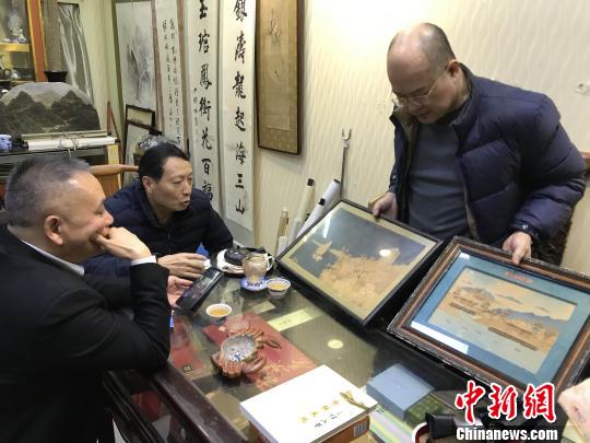 陈晖展示日本回流的“福州三宝”之一的国家级非物质文化遗产软木画。　郑松波 摄