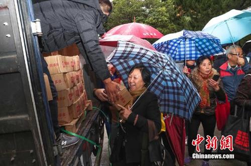 资料图：上海百名居民在雨中排成一条长龙，领取刚到货的秭归脐橙。供图