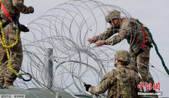 资料图：美国士兵在美墨边境安装铁丝网，严防移民入境。