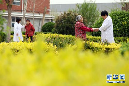 5月5日，在河北省衡水市桃城区一家养老康复医疗中心，护工在陪老人散步。新华社记者 牟宇 摄