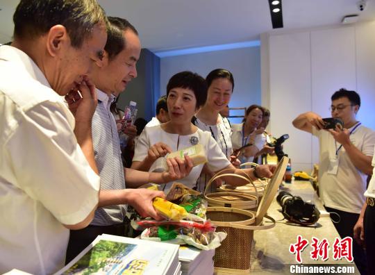 6月12日，松溪县书记(左3)黄美萍向民众推广版画及旅游产品。　张丽君 摄