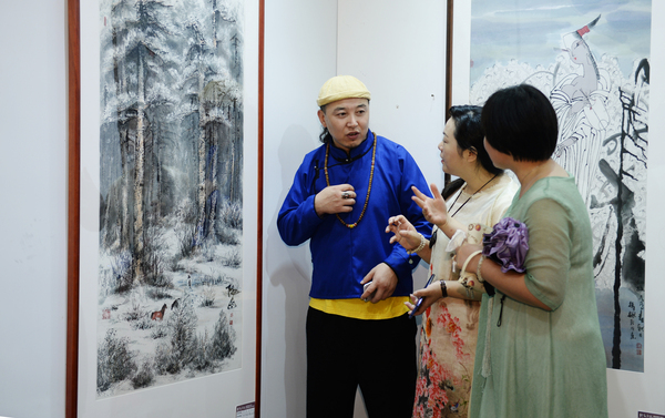 7、聚集在北京宋庄的内蒙古画家阿拉腾在向观众介绍他的作品