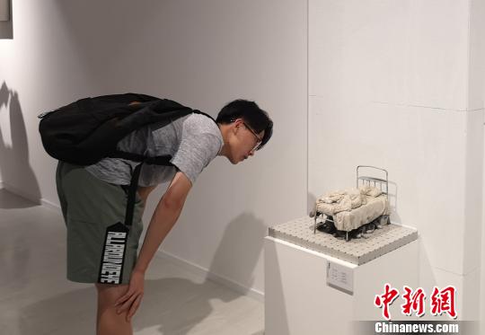 图为观众观看小尺度具象雕塑作品。　刘贤 摄