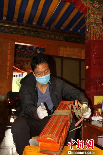 图为西藏自治区古籍保护中心古籍保护部副主任才洛打开古籍进行登记。　赵朗 摄