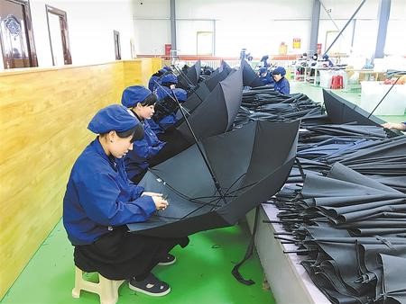 工人在东乡县振兴雨具扶贫车间加工雨伞