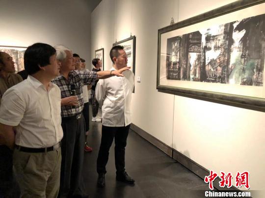 台湾知名画家江明贤向来宾讲述创作过程。　朱晓颖 摄