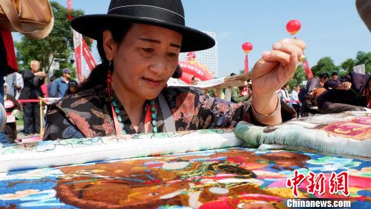 图为藏族“绣娘”正在展示藏绣技艺。　李隽 摄