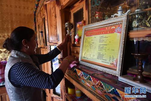 在青海省玉树藏族自治州治多县治渠乡同卡村，村民昂文西让的妻子布沙措江卓玛清理家里的柜子（9月12日摄）。新华社记者 孙瑞博 摄