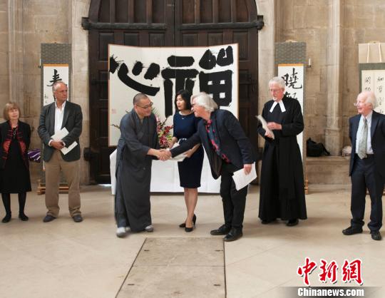 英国皇家水彩协会前主席大卫·帕斯特(右3)与月真法师(左3)握手，恭贺展览开幕 。??　王子岚 摄