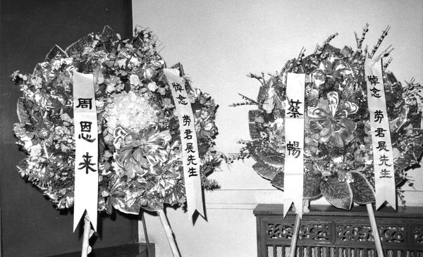 9--1976年1月8日，在劳君展先生追悼会的会场上，摆放着全国政协周恩来主席所献的花圈